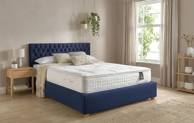 An ottoman bed upholstered in a blue material with a pocket spring mattress.